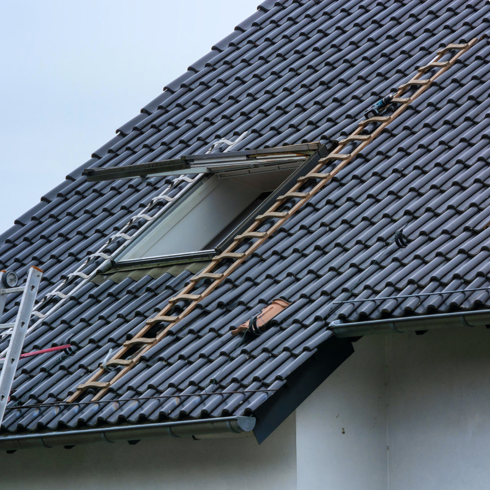 Dachfenstereinbau mit neuer Eindeckung aus dunklen Dachziegeln